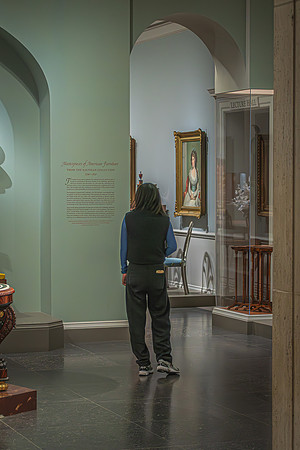 A visitor contemplates a display in the elegant setting of the National Gallery, creating a moment of connection between the present observer and the historical artwork.