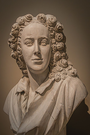 An intricately carved wooden bust with detailed curls and expressive features, exhibited at the National Gallery.