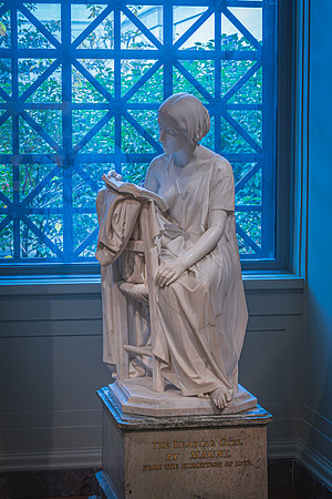 "The Reading Girl," a marble sculpture by Pietro Magni, highlighted by natural light in the National Gallery.