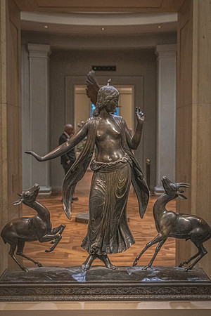A bronze statue of a goddess with outstretched arms, dancing among deer, displayed in the National Gallery.